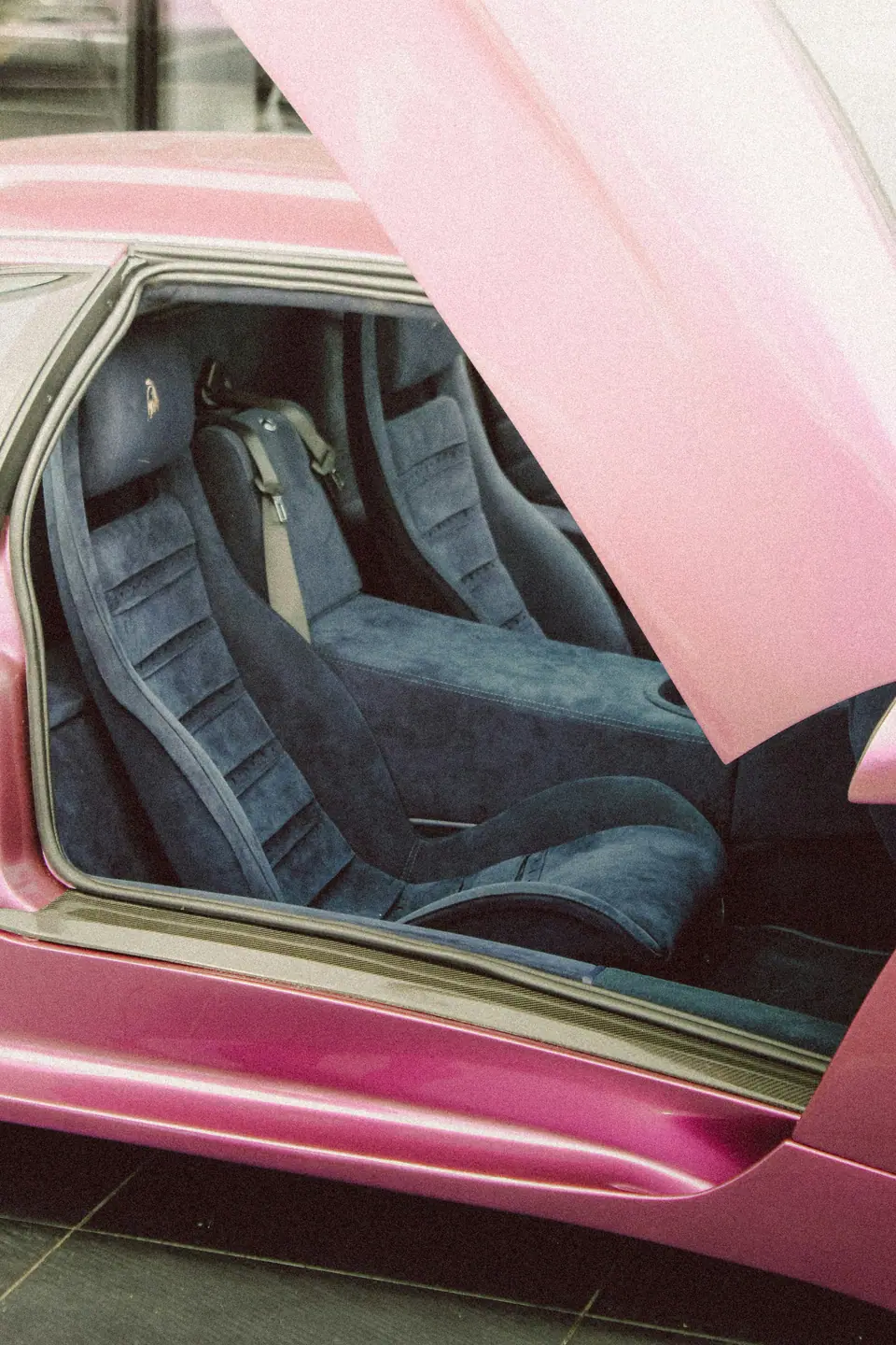 Intérieur d’une voiture rose, sièges baquets, lumière de salon