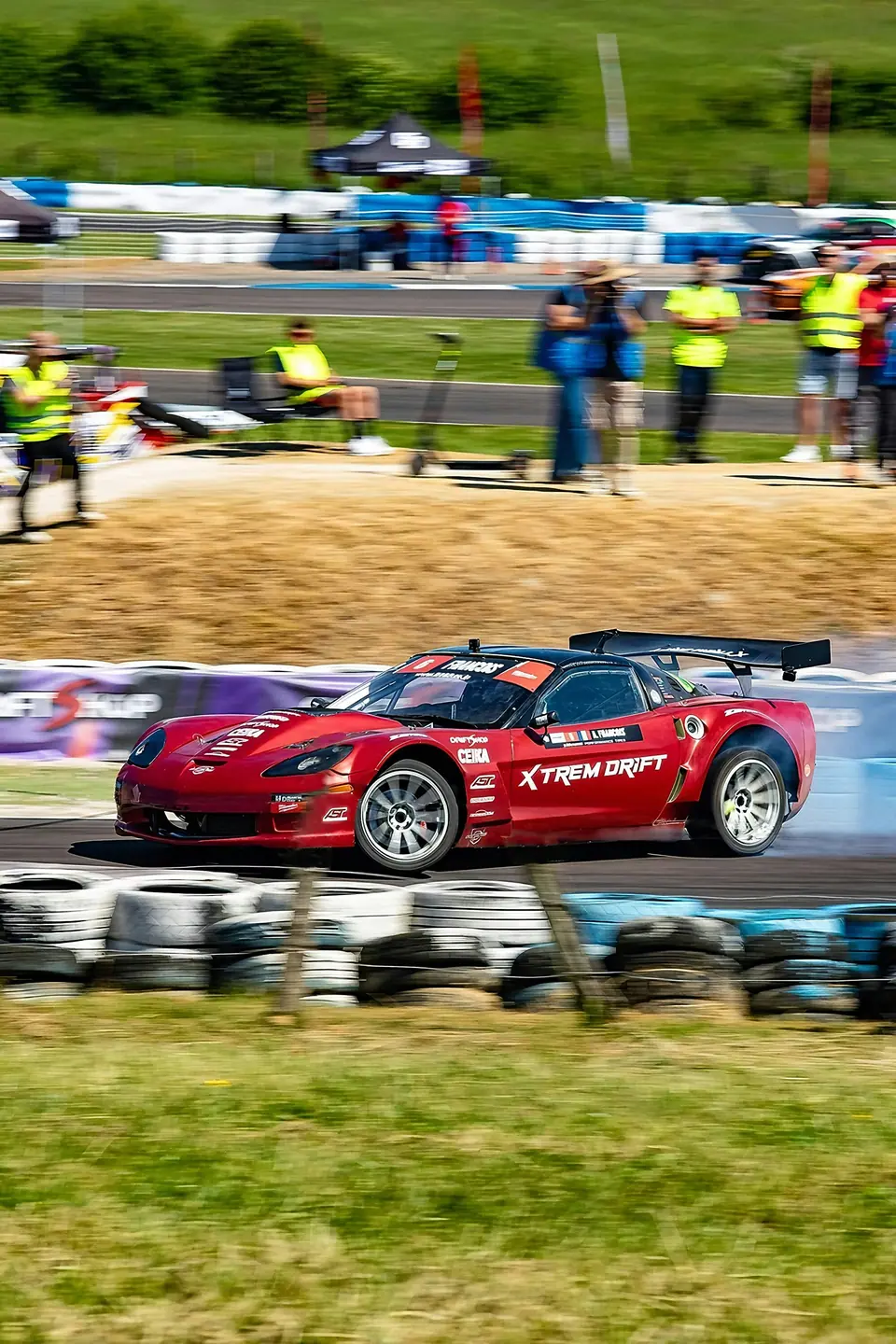 Voiture de drift rouge dans un nuage de poussière